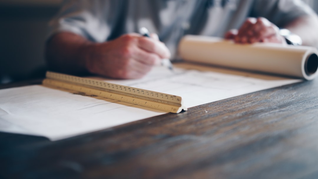 Person drafting plans on a blueprint at a desk