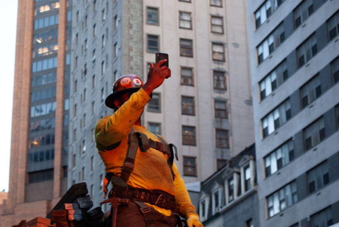 Construction worker taking a selfie on a job site with a smartphone